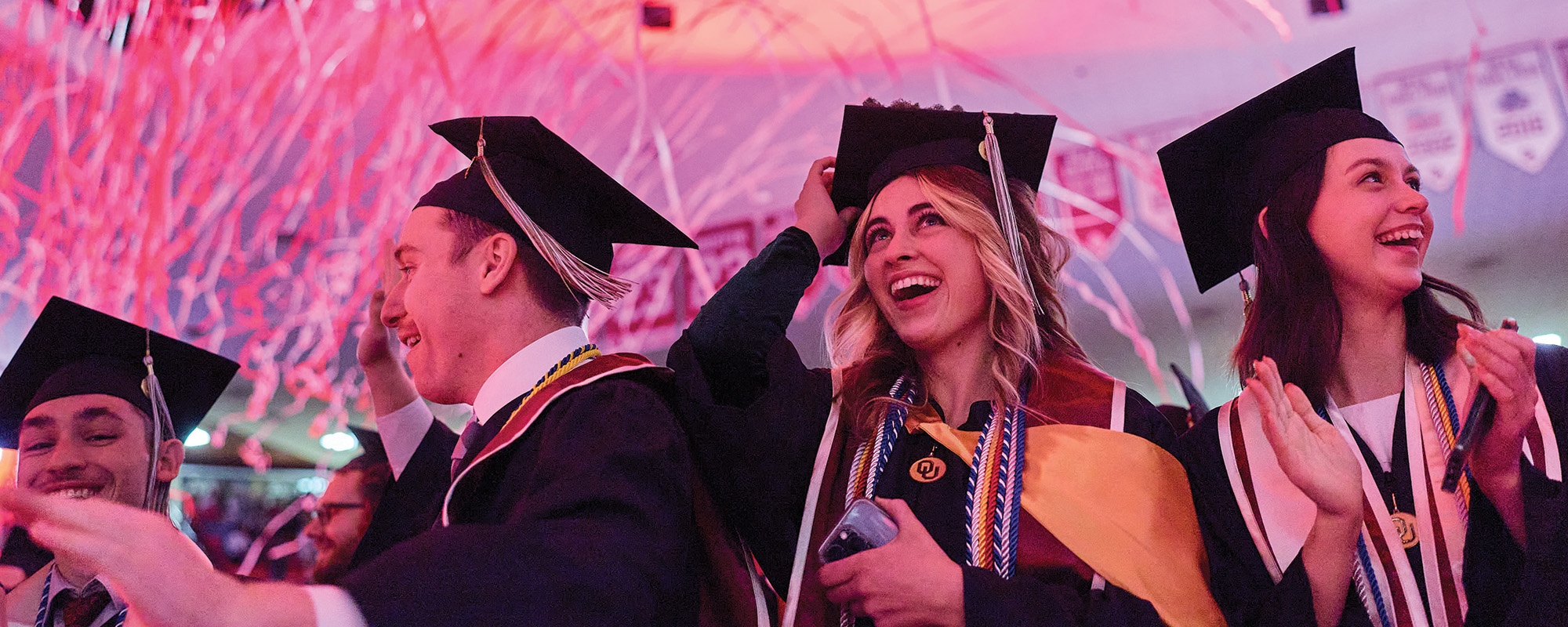 Graduates celebrating during college convocation ceremony.
