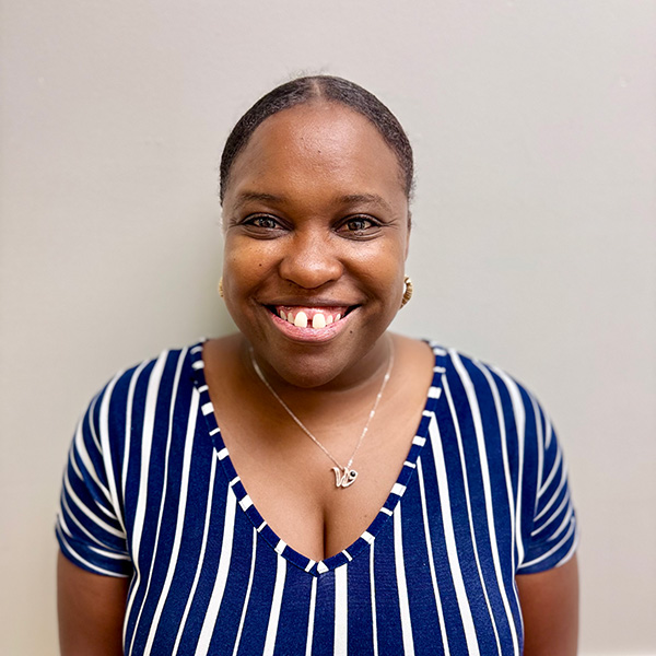 Woman with blue shirt and curly hair smiling