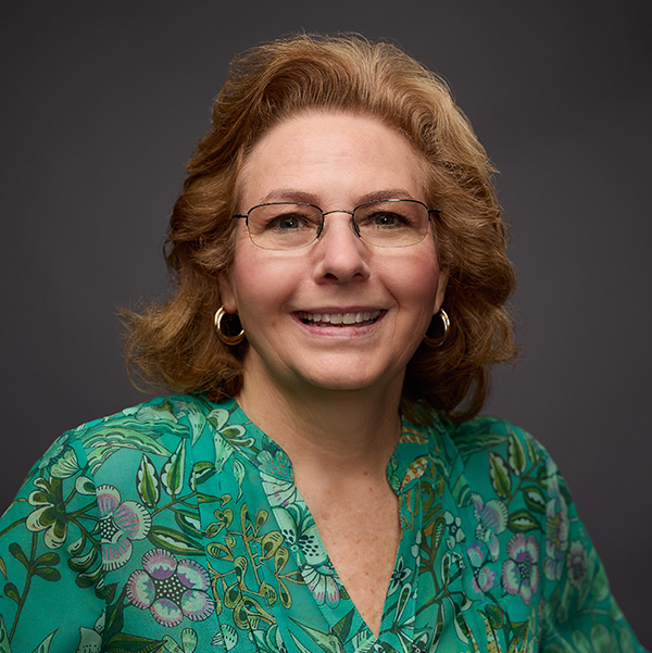 Sherry Cox in a white shirt with a blue scarf