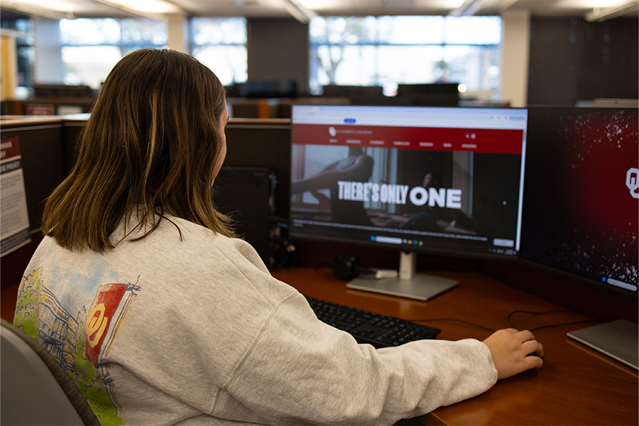 Student looking at ou.edu homepage on computer.