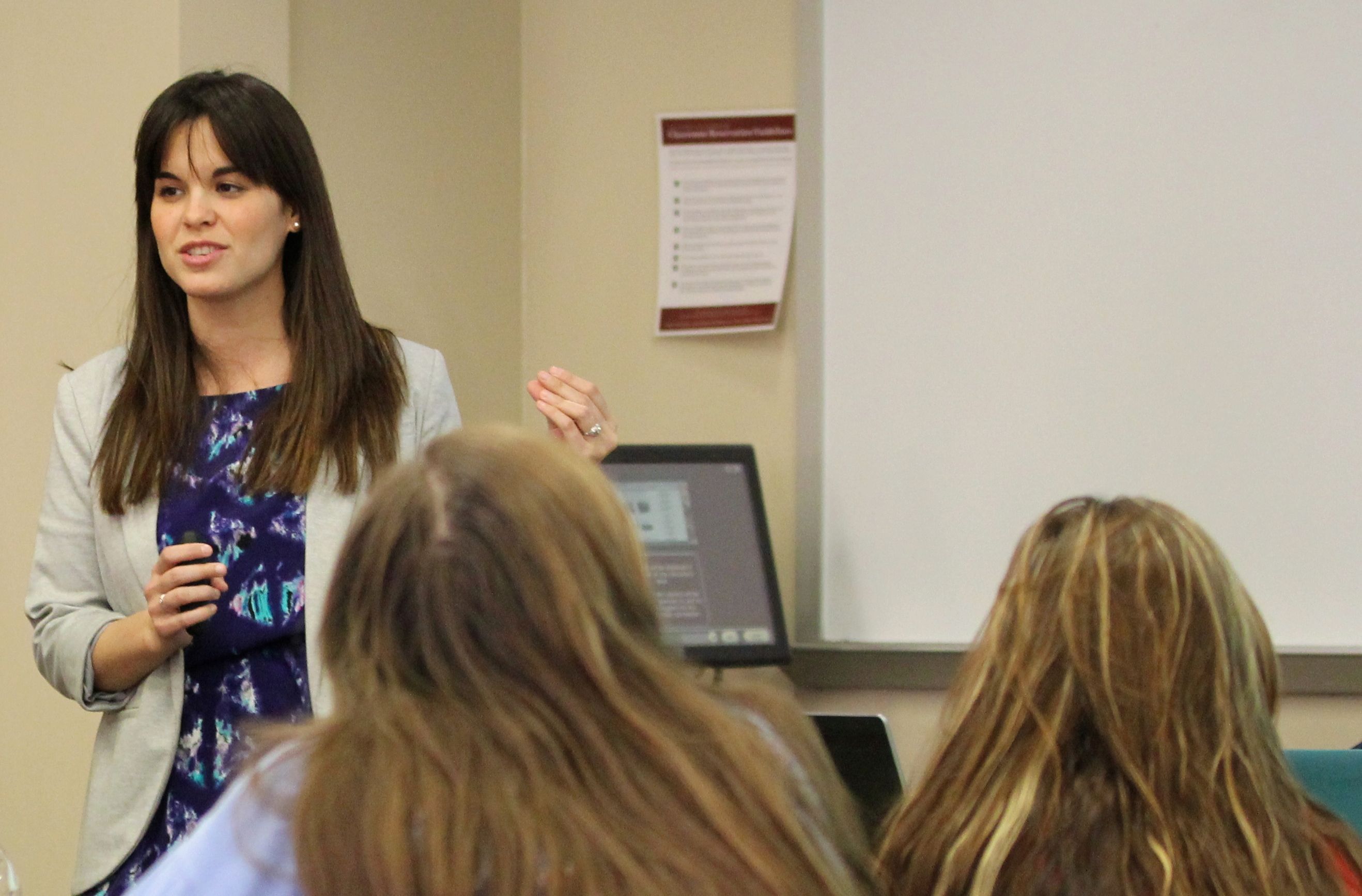 A person standing at the front of a classroom, teaching.