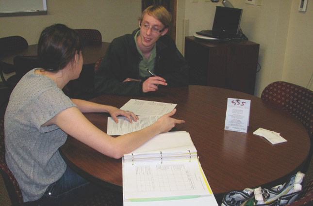 A tutor working with a student at a table. 