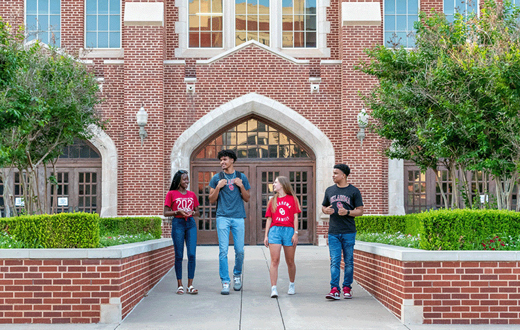 four students walking our of building together.