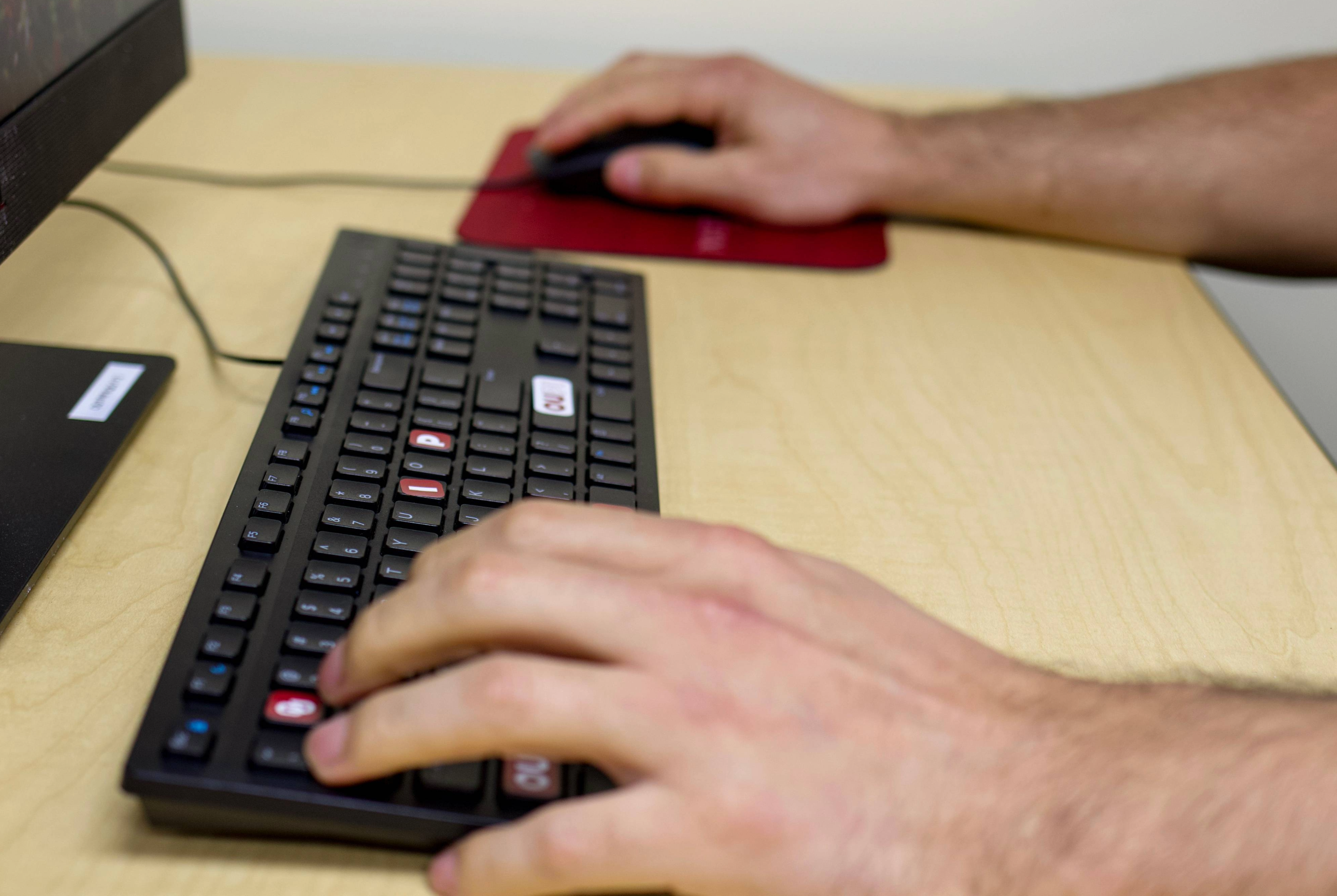 Hand typing on a computer.