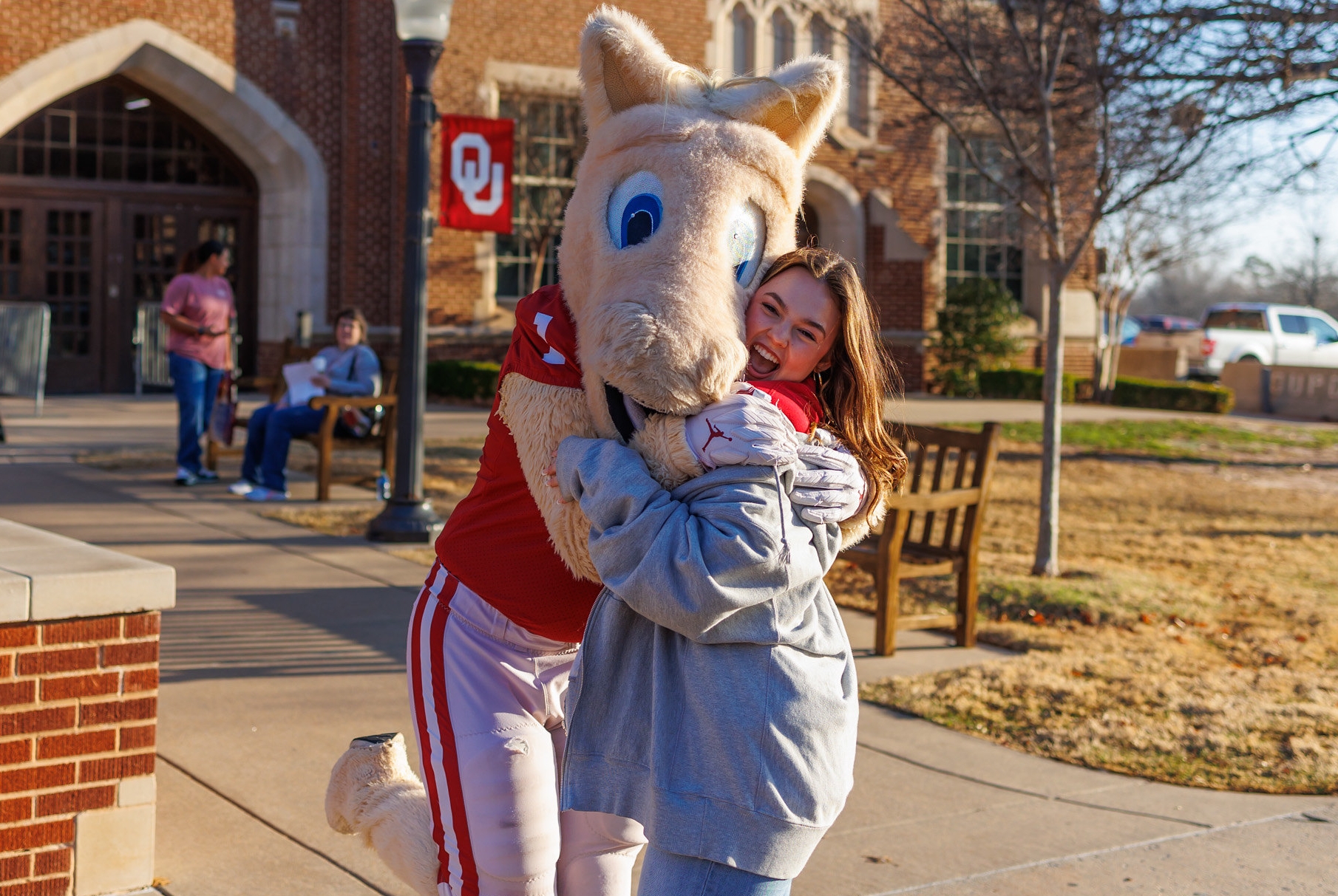 Student at an OU event hugging OU's mascot.