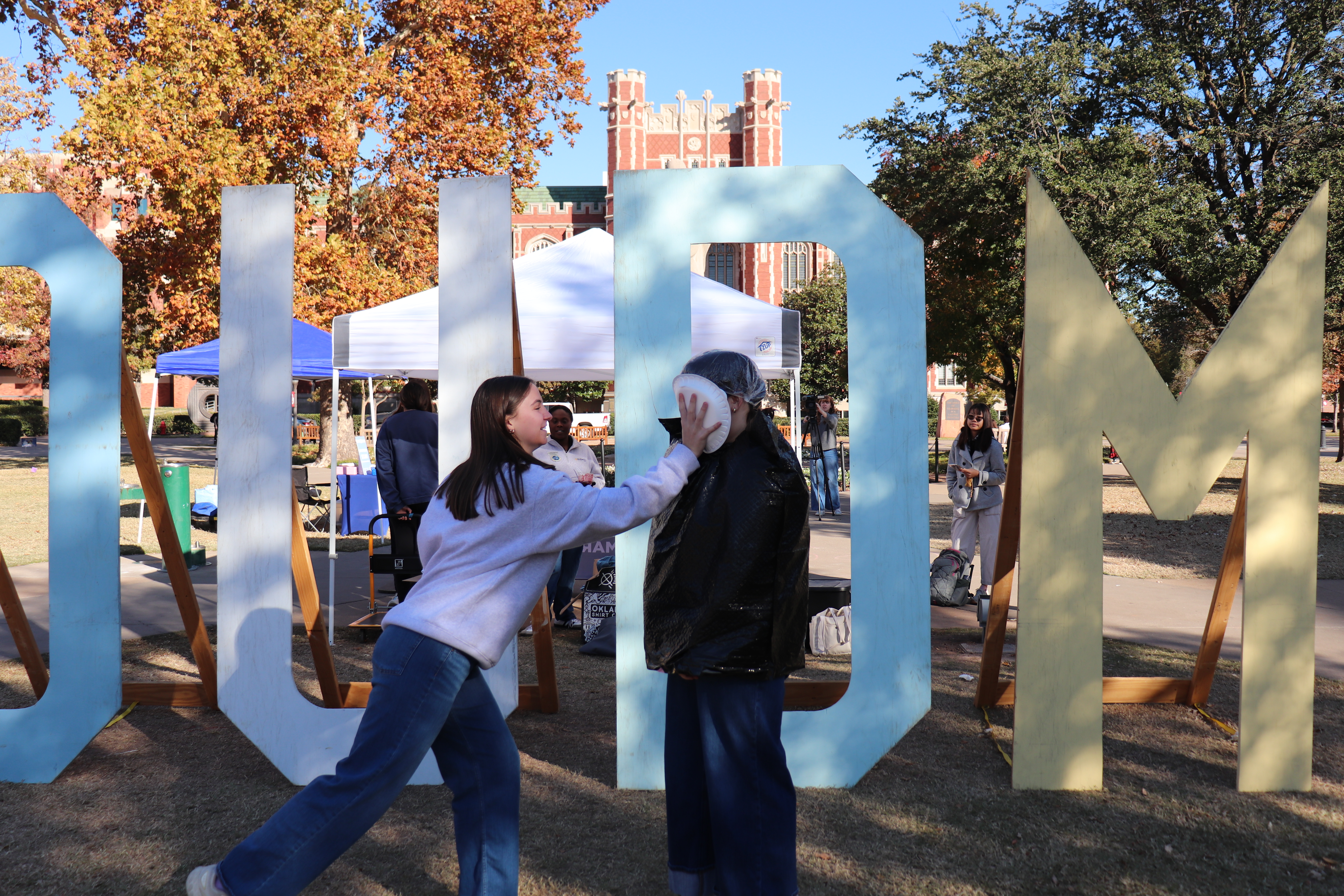 Student throwing a pie in another's face for OUDM