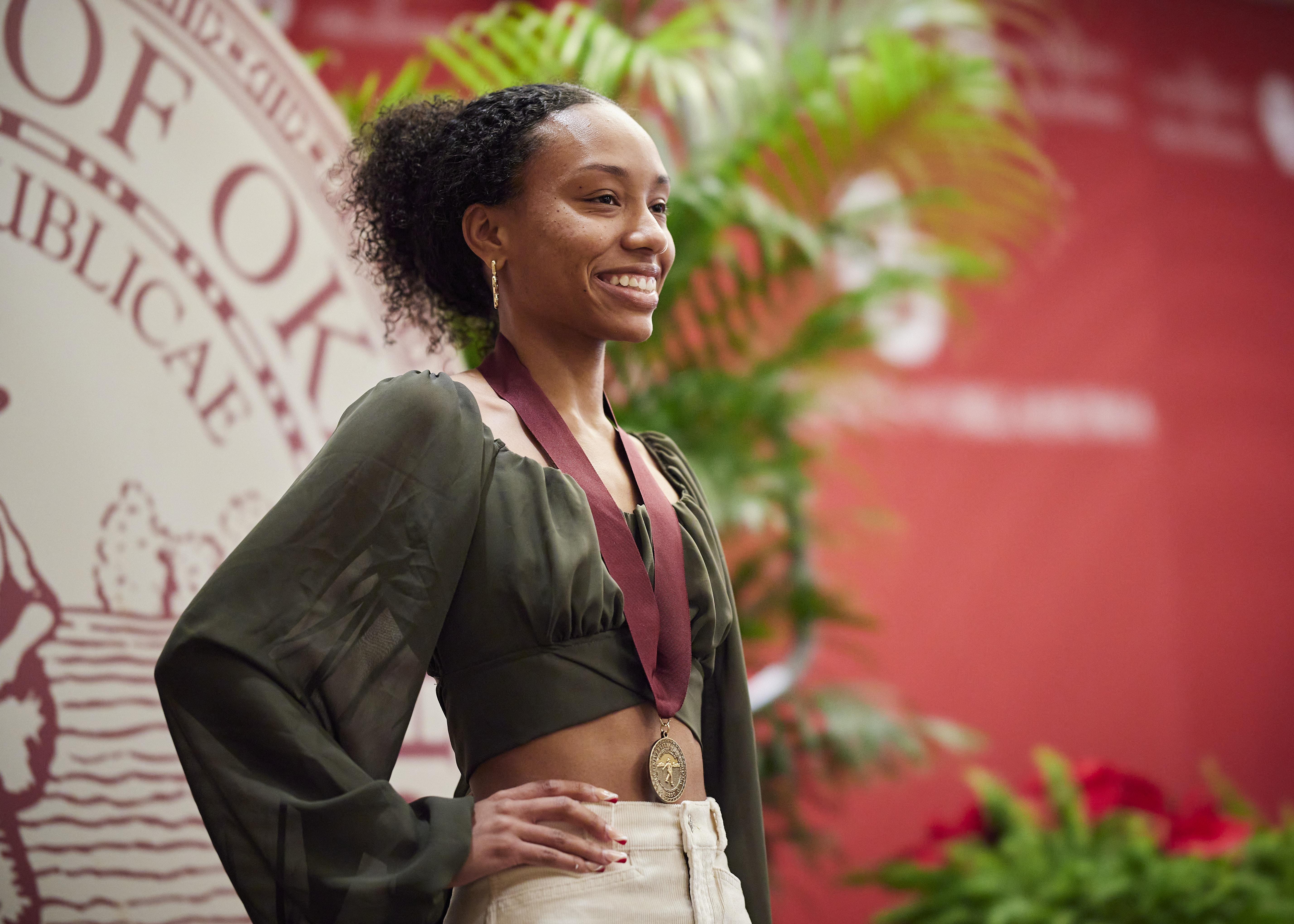 A student with a medal standing on stage.