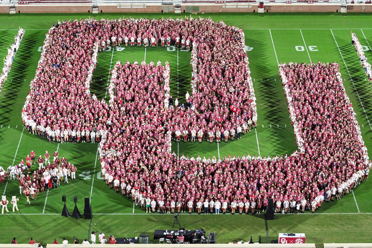 Class of 2029 posing together in a shape of an OU on the field