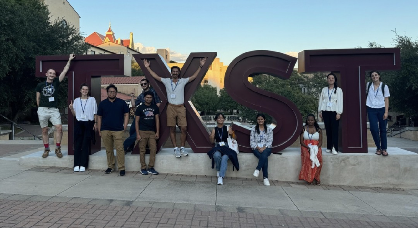 Photo of DGES students in front of a Texas State University sign.