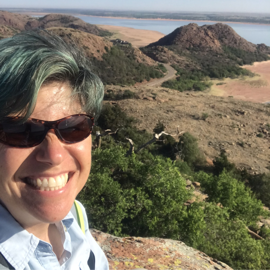 Photo of Priscilla on top of a mountain.