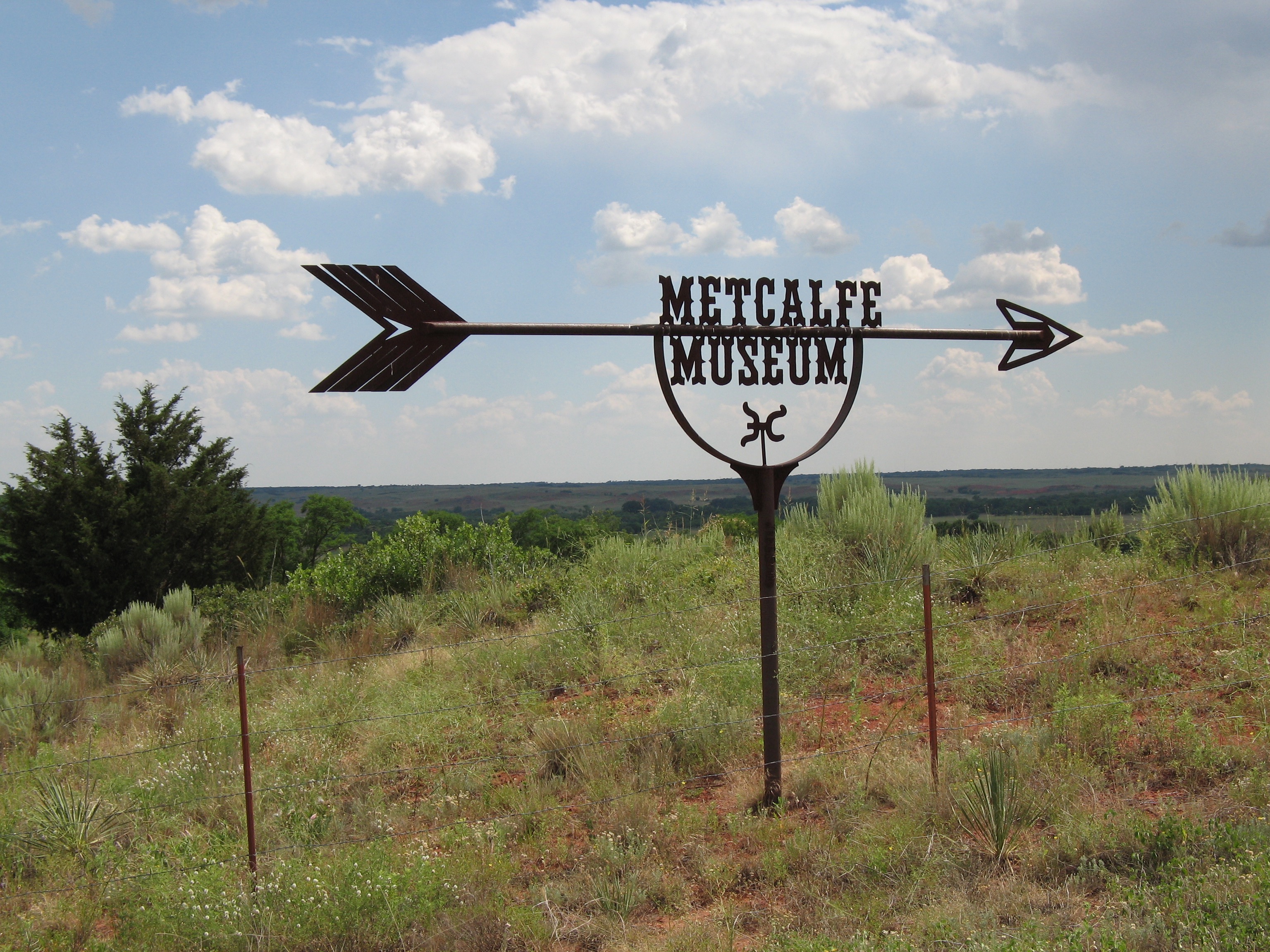 Metcalfe Museum roadside sign in a short grass prairie
