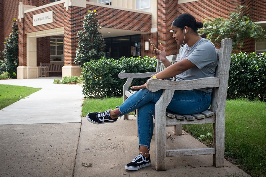 Student sitting on a bench outside Kaufman Hall