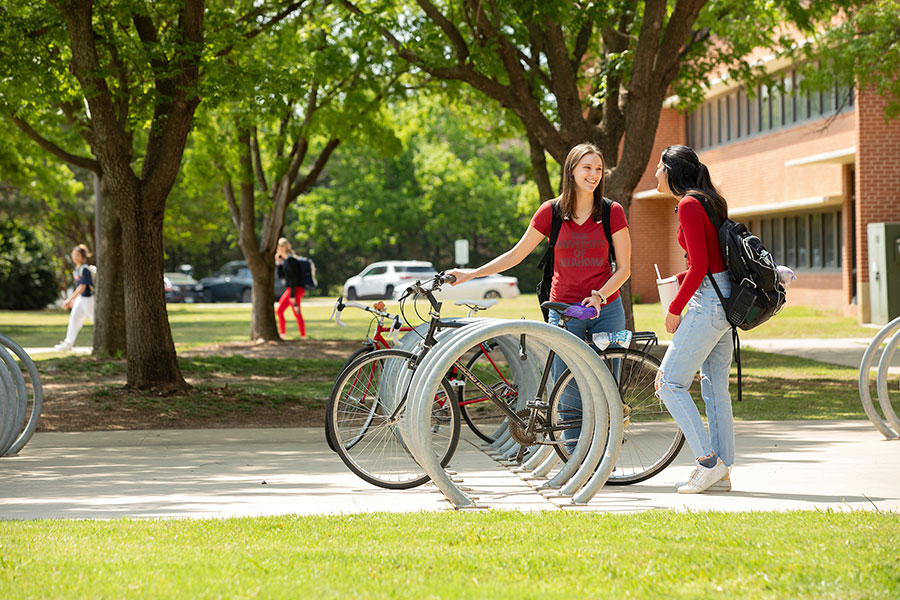 two students standing at bike rack.