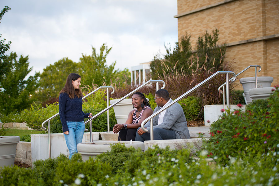 Students sitting outside at Tulsa campus.