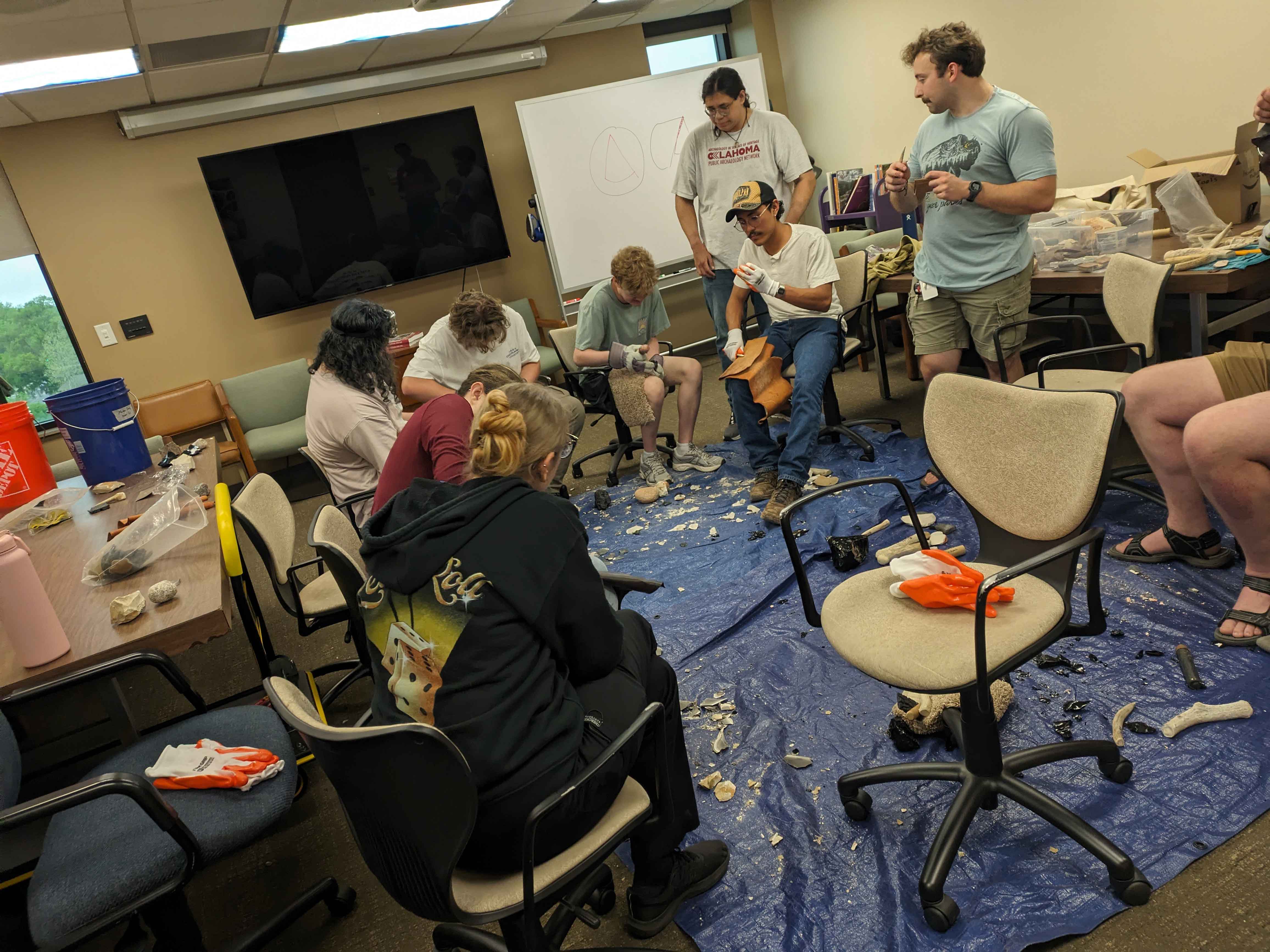 Undergraduate Anthropology organization students doing flintknapping.