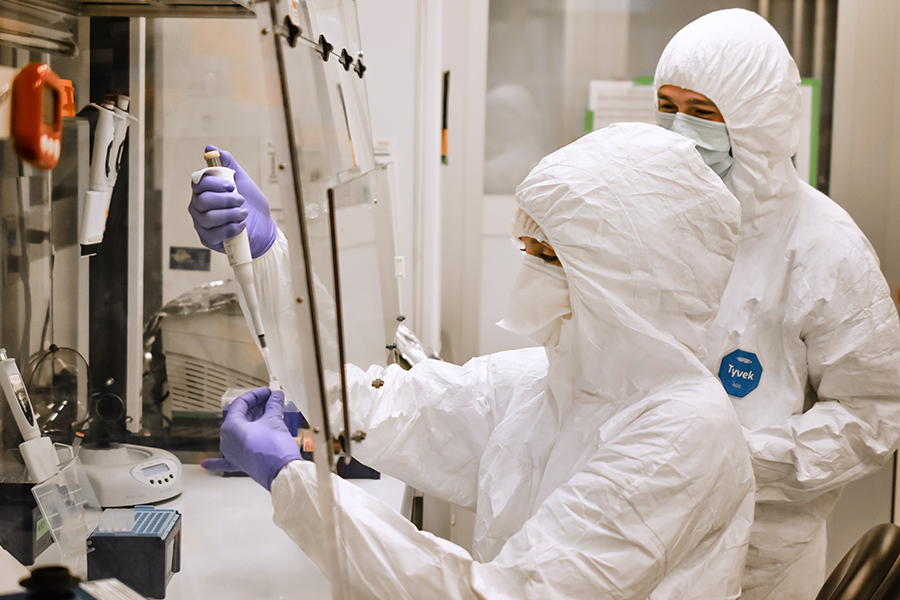 Dr. Courtney Hofman and Molly Zuckerman processing samples while wearing protective gear.