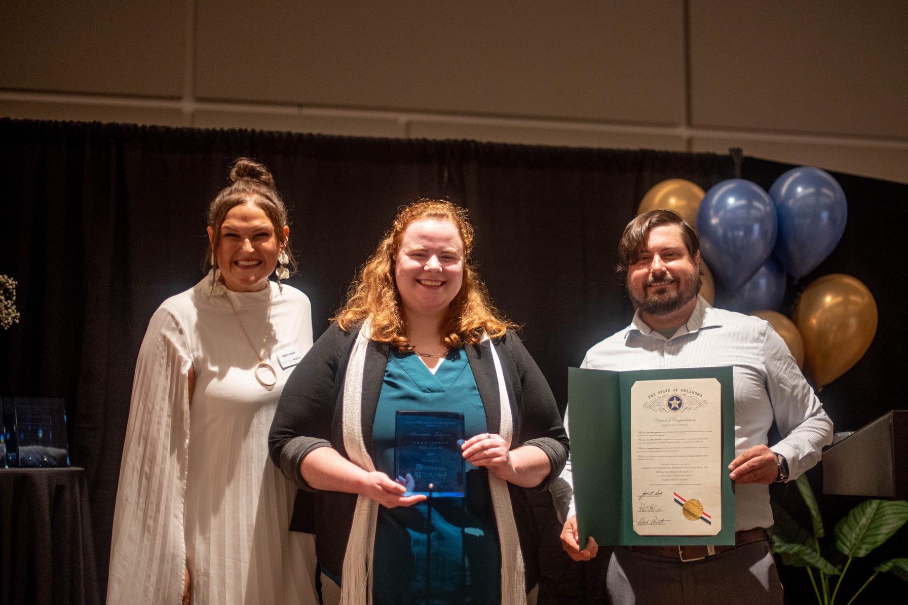 Dr. Johnson accepting her award with two others on stage at Norman Next award ceremony. 