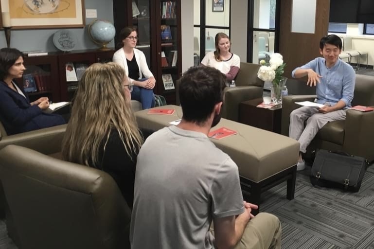 Simon Han speaking with a group of creative writing students at OU. 