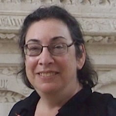 Joyce Coleman standing in front of a stone facade