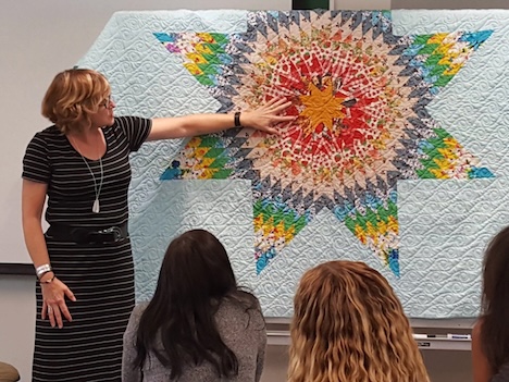 Roxanne Mountford teaching with her quilt at a summer workshop. 