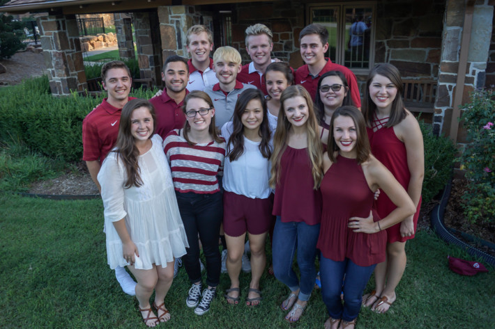 A large group of students pose together on OU's campus.