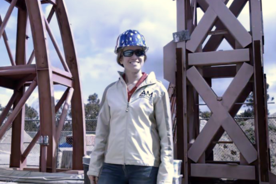 Amy Cerato in a hardhat standing working in the field.