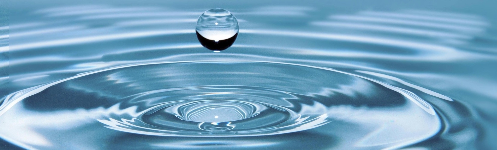 Drop of water falling into pool of water.