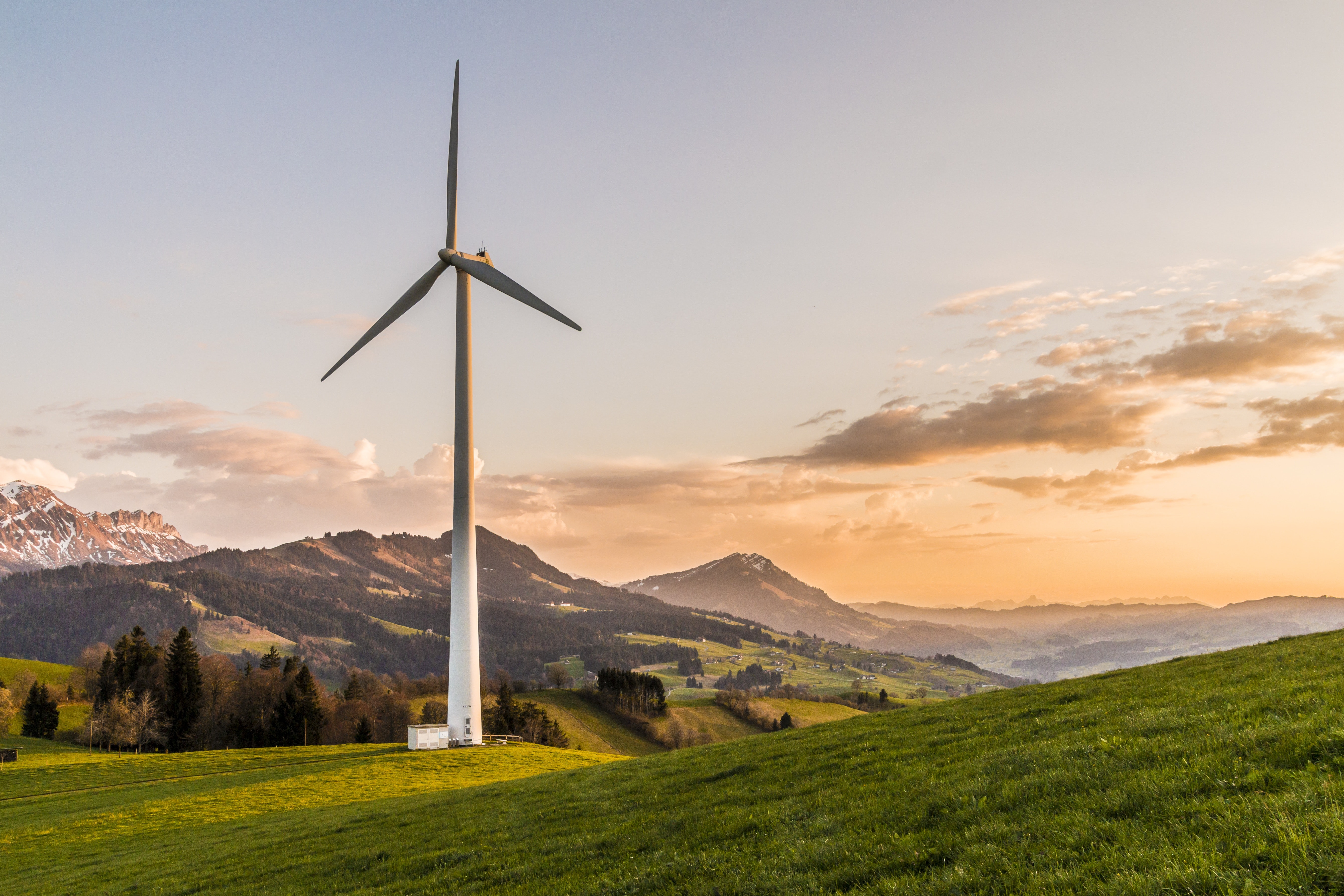 A large wind turbine surrounded by green hills.
