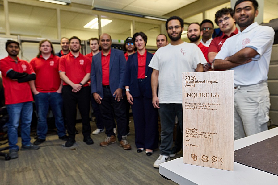 The Inquire Lab team stands as a group around the award. 