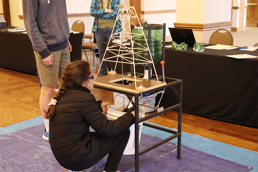 Student in front of tower model.