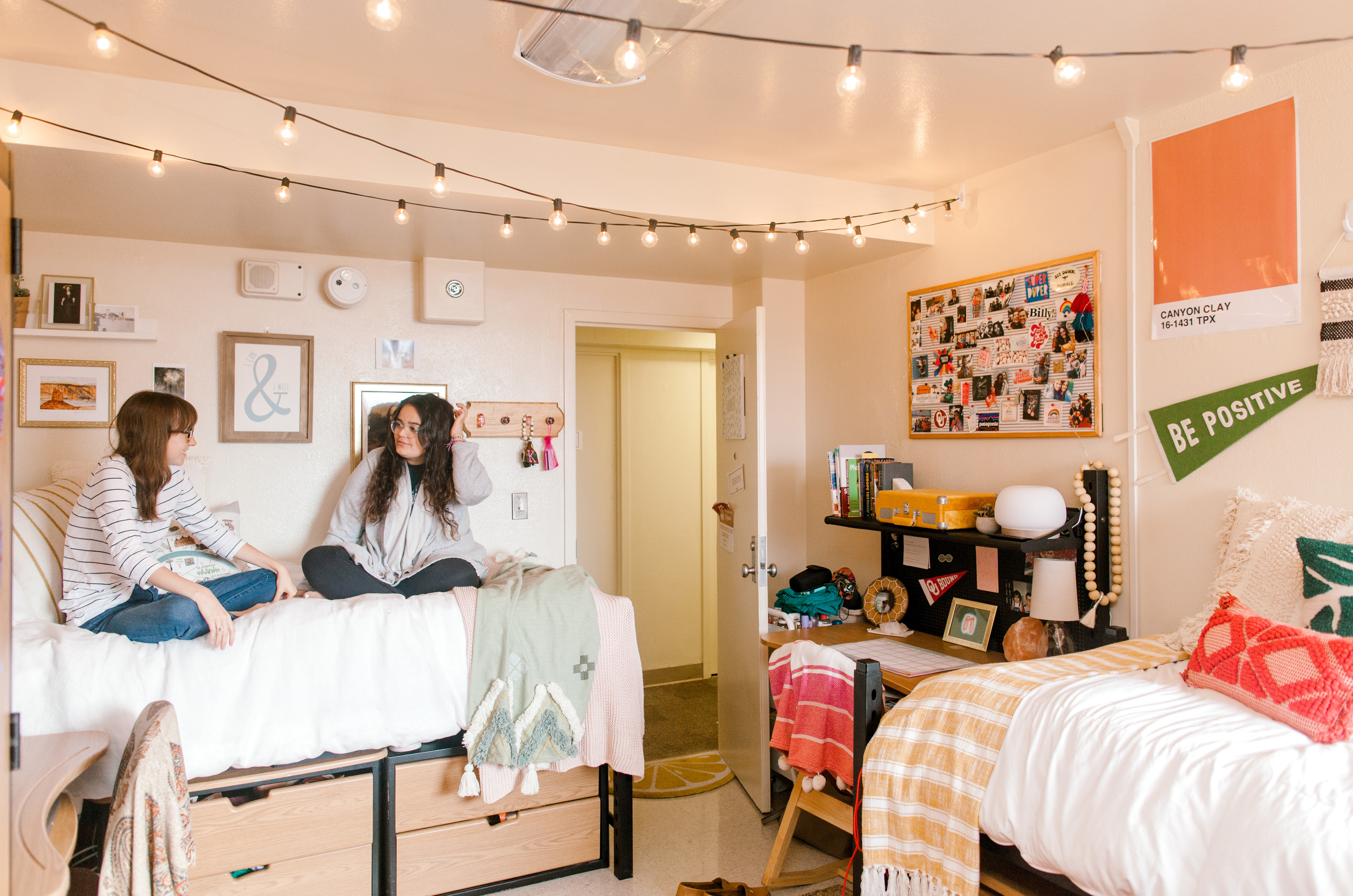 students in residence hall sitting on bed