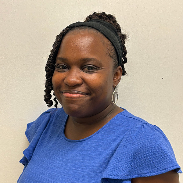 Woman with blue shirt and curly hair smiling