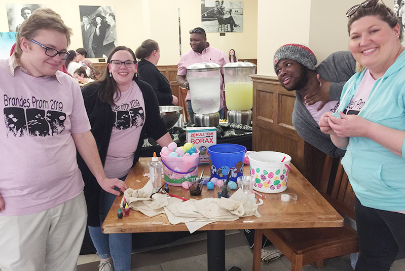 Four students standing at table with Easter eggs