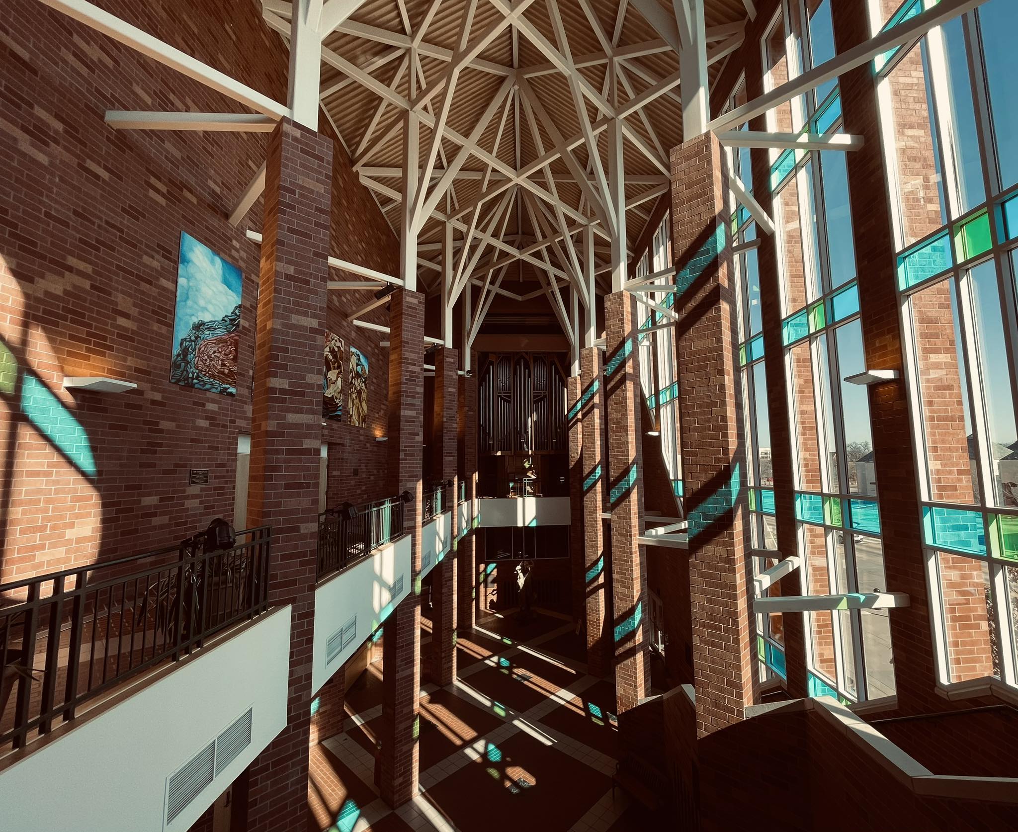 Gothic Hall view from balcony with light streaming through colored windows.