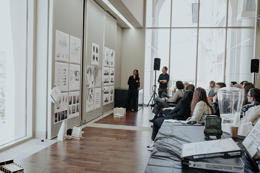 Students in a classroom, studying images on a wall.