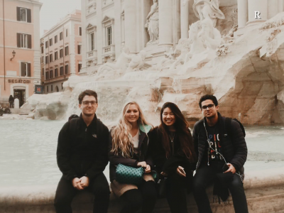 Four students sitting in front of a fountain in Rome.