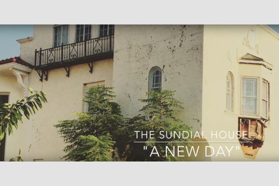 A building facade with the text "The Sundial House A New Day".