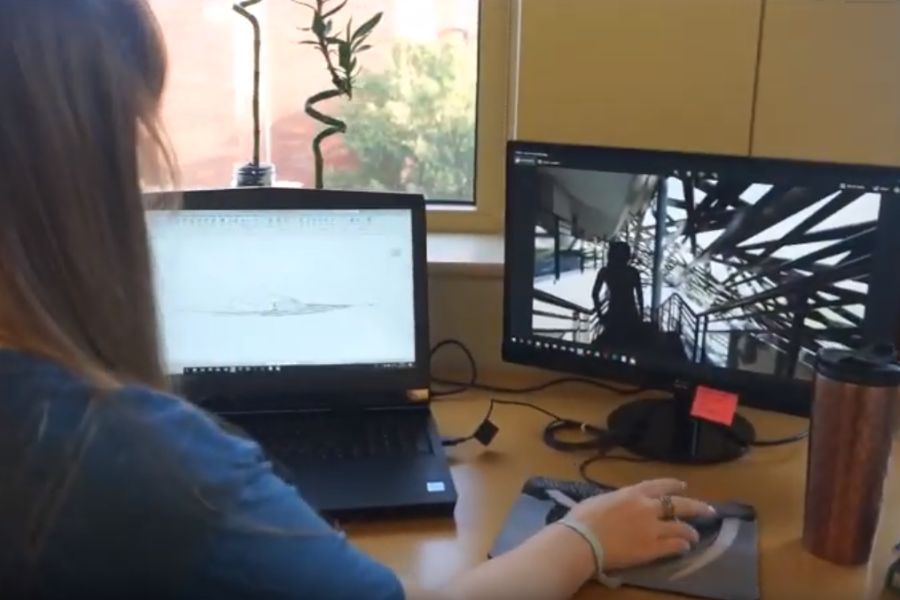 Student sitting at desk working on two screens editing project film.