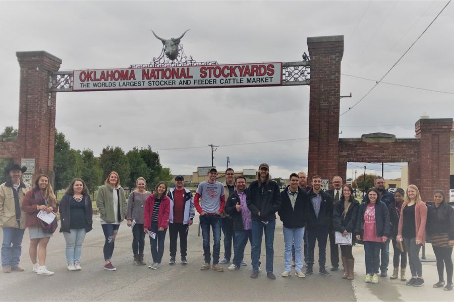 Students from historic preservation course taking group photo at Oklahoma's National Stockyard entrance.