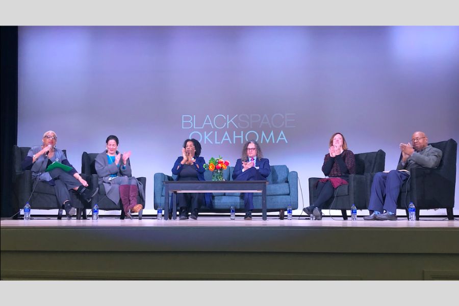 6 panelists sitting on a stage in front of a screen that reads blackspace Oklahoma