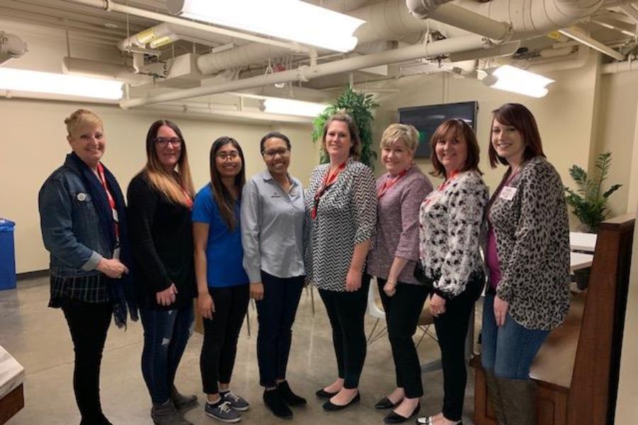 8 women of different ages posing for a photograph indoors