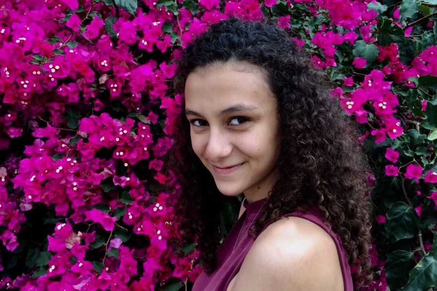 Headshot of Kristi Saliba in front of purple flower bush.