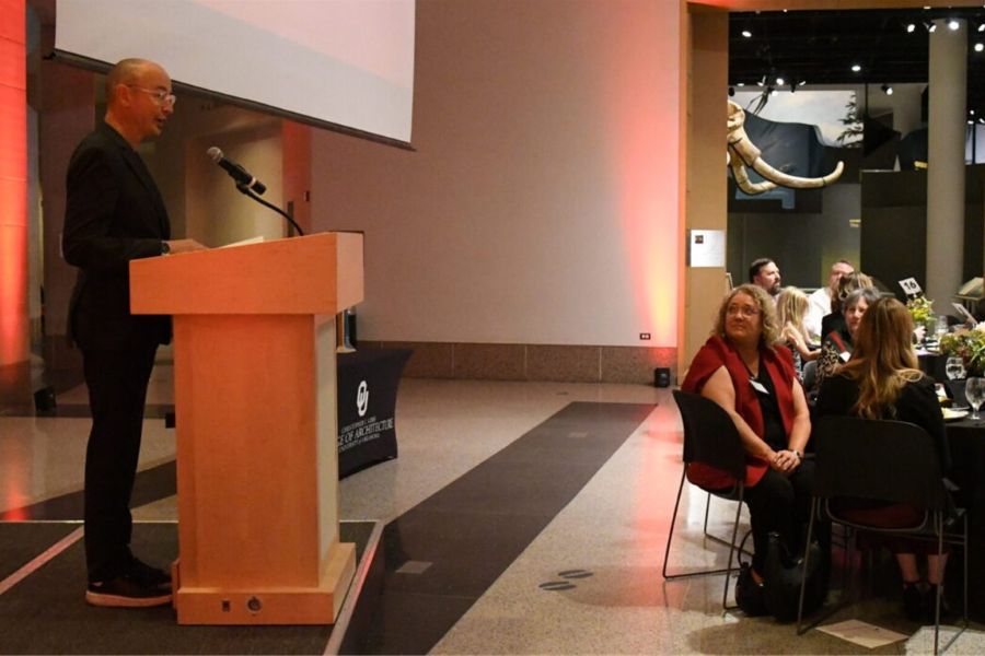 Gibbs College Dean Hans E Butzer at a podium speaking to banquet guests.