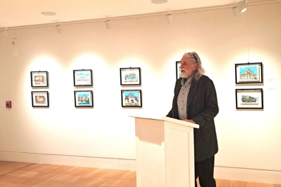 David Boeck at a podium in front of his sketches of Ukranian churches.