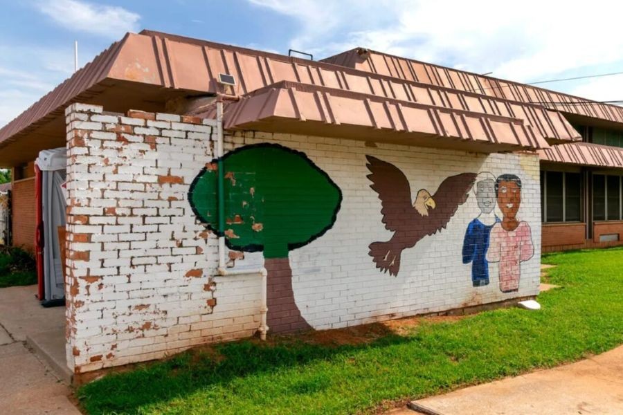 A mural at the Garden Oaks community center featuring a tree, a bald eagle, and two human figures.