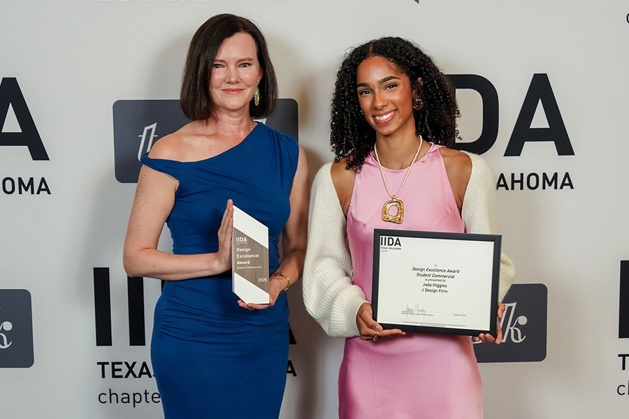 Stacy Murphy and Jada Higgins stand side by side at the IIDA Texas-Oklahoma Design Excellence Awards. Murphy holds the Design Excellence Award trophy, while Higgins holds a framed certificate recognizing her student commercial project.
