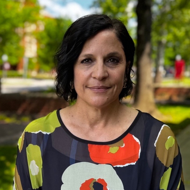 Marlene Landini in a gren and blue blouse outside.