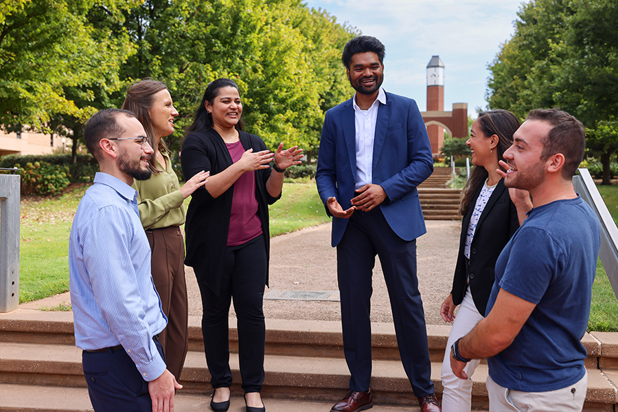 A Gathering of individuals discussing on a paved pedestrian walkway.