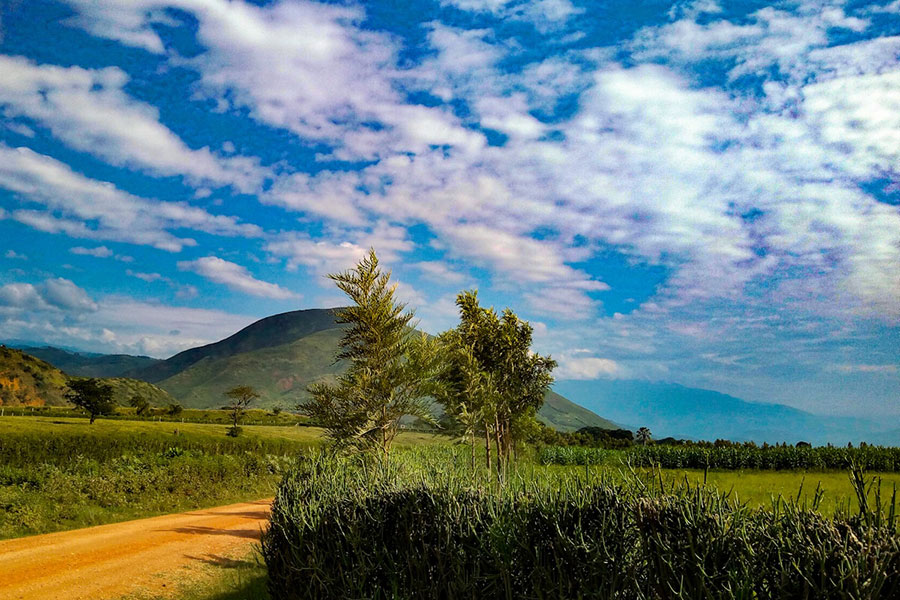 Uganda countryside with mountains and fields.