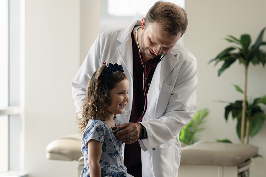 A doctor using a stethoscope to listen to a child's breathing.